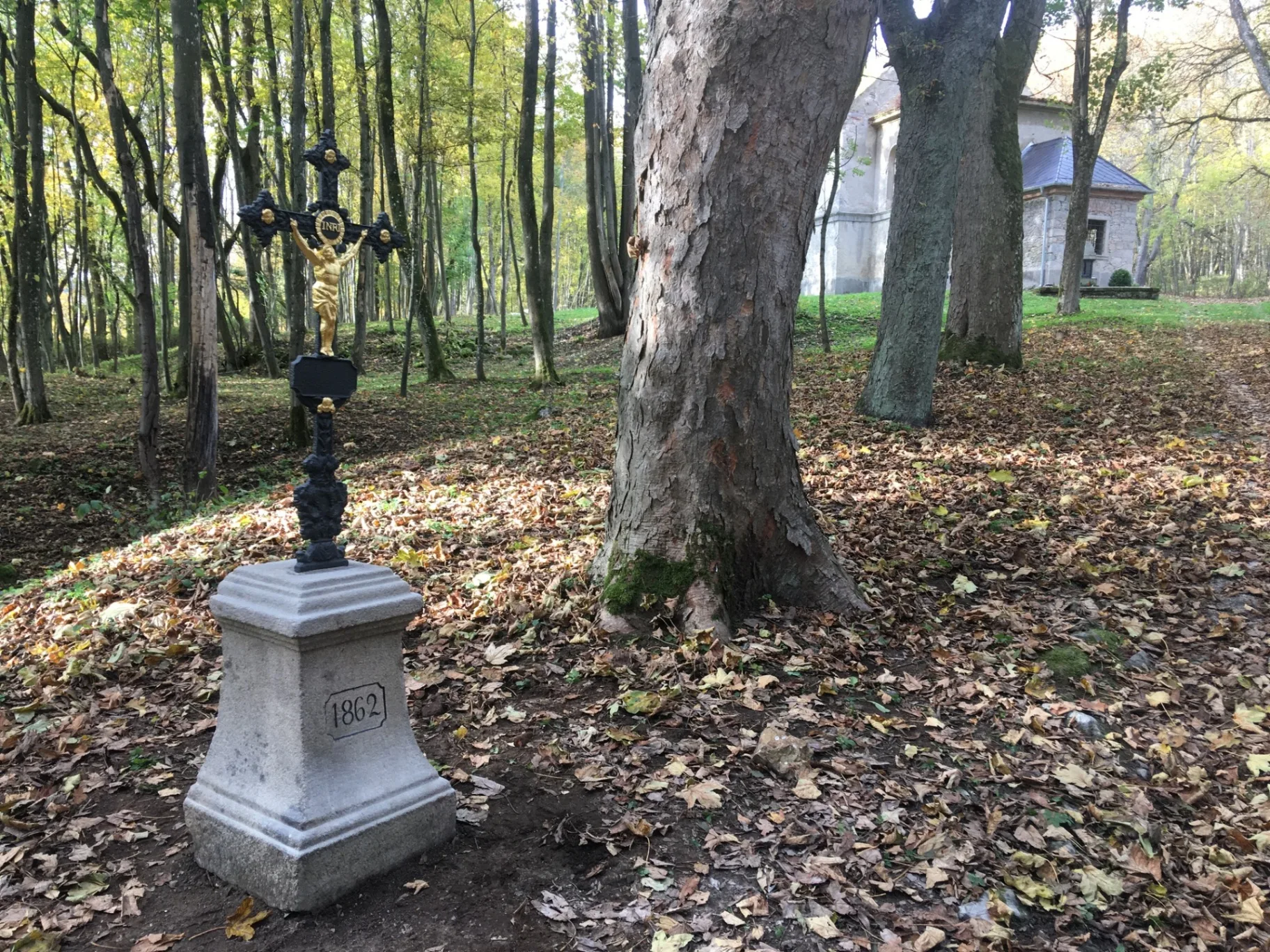 Litinový kříž s pozlacenou figurou na kamenném podstavci z roku 1862